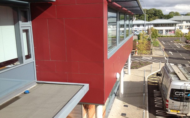 Red cladding panels and a flat roof on a commercial building