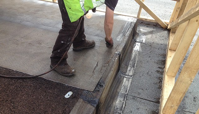 Roofers laying membrane on an industrial roof at Seagate, Derry